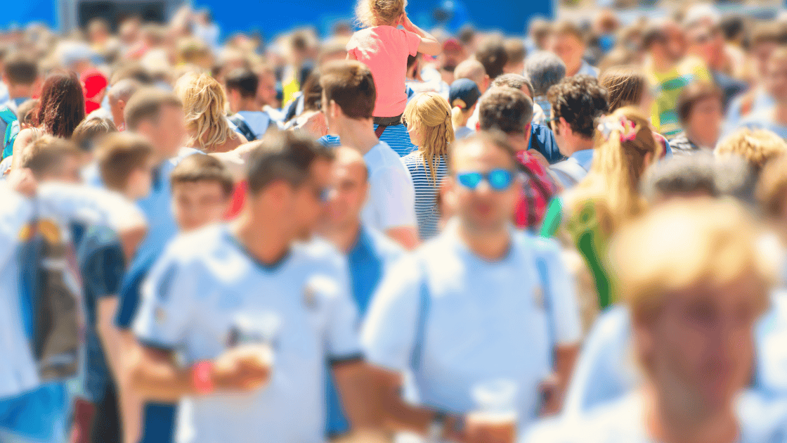 Crowd of people in the summer wearing t shirts and drinking beer