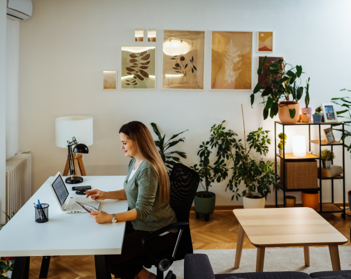 A lady working at home looking at her laptop on her desk